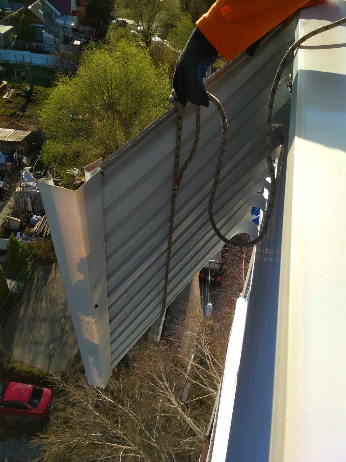 Спасатели убрали нависавший над тротуаром лист обшивки балкона